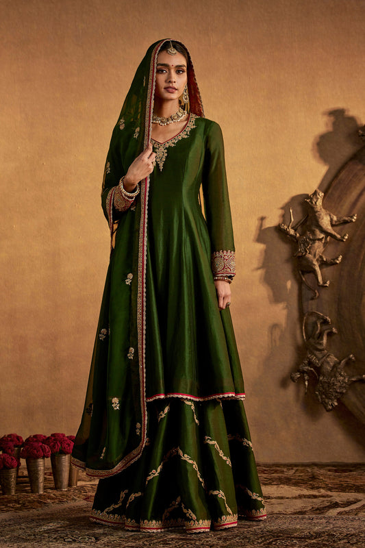 Model in a juniper green sharara set, subtle embroidery, traditional South Asian dress, stylish formal ethnic wear.