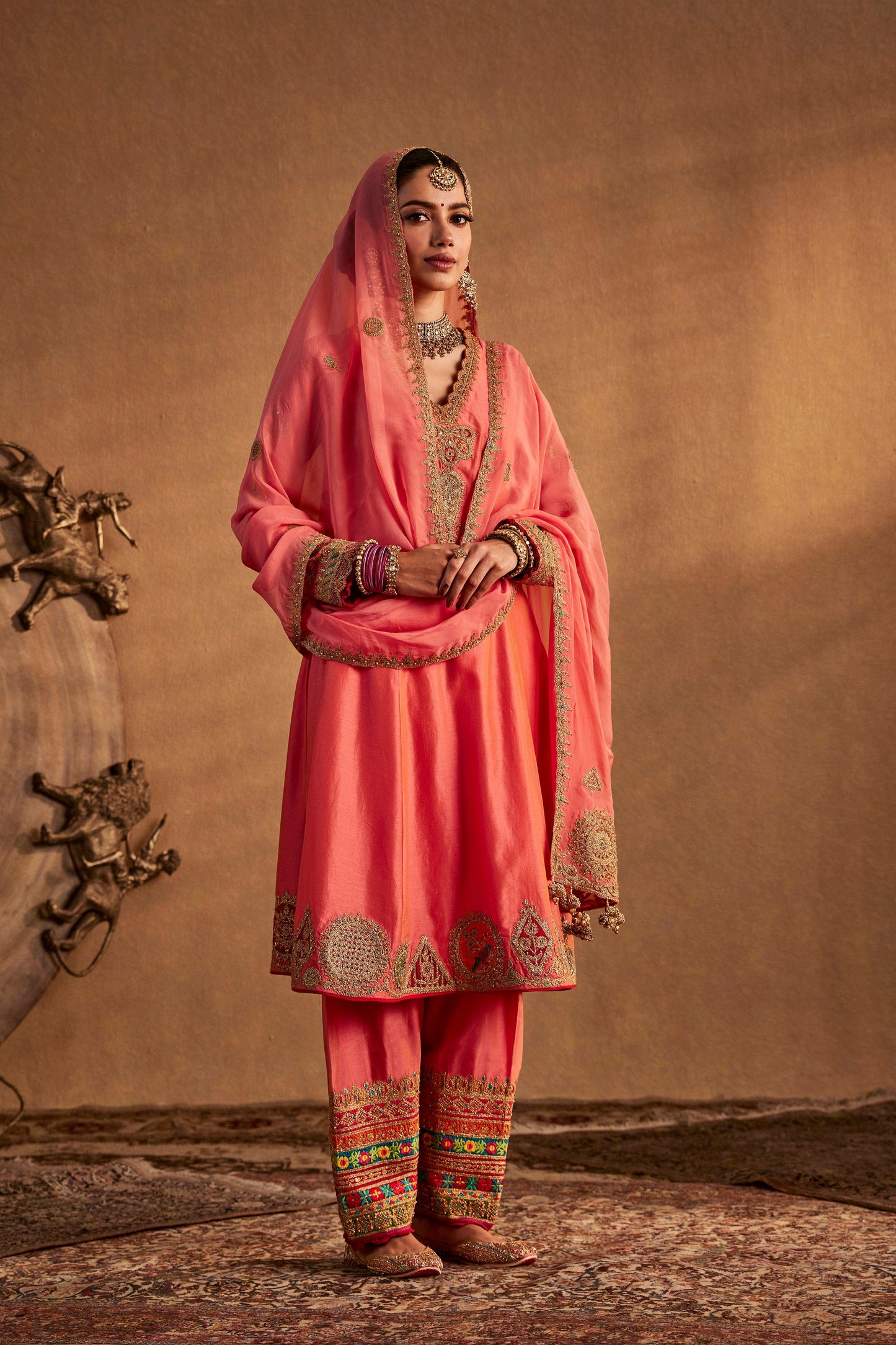 Model in a coral peach kurta set, traditional South Asian dress, simple elegant design, everyday ethnic fashion.