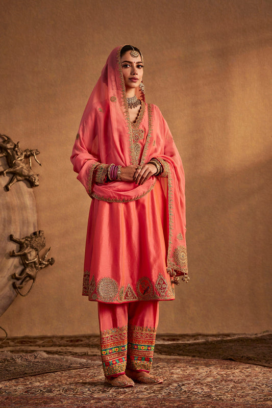 Model in a coral peach kurta set, traditional South Asian dress, simple elegant design, everyday ethnic fashion.