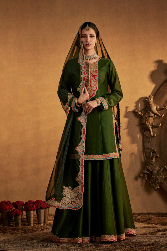 Woman in pine green sharara set with gold embroidery, cultural South Asian attire, full length view