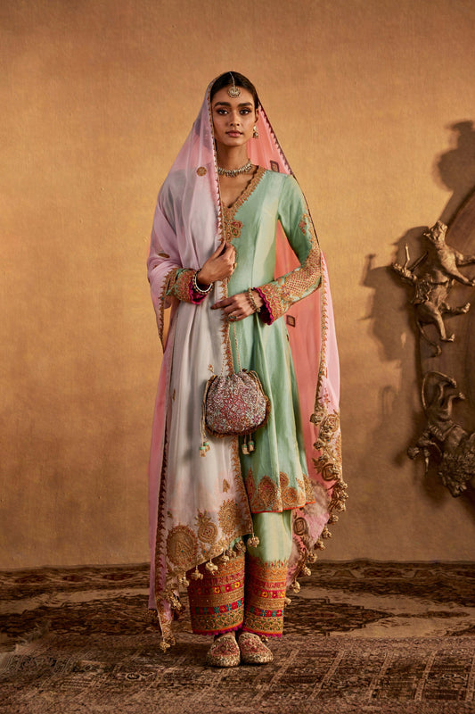 Model in pastel Rimple and Harpreet bridal lehenga with pink dupatta and heavy embroidery, perfect for a day wedding.