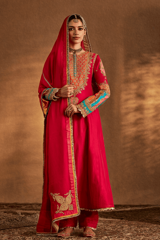 Woman in Rani Pink Archival Kurta Set, embroidered traditional South Asian dress, full length.