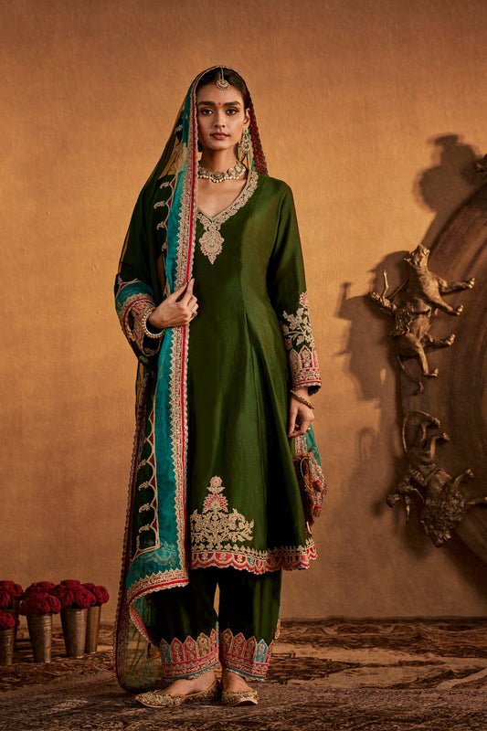 Model in a deep green classic kalidar set with elaborate embroidery, traditional South Asian formal dress, regal.