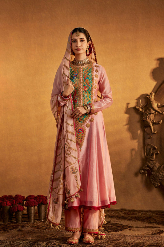 Model in a soft pink kurta set with colorful embroidered details, cultural everyday fashion, comfortable ethnic wear.