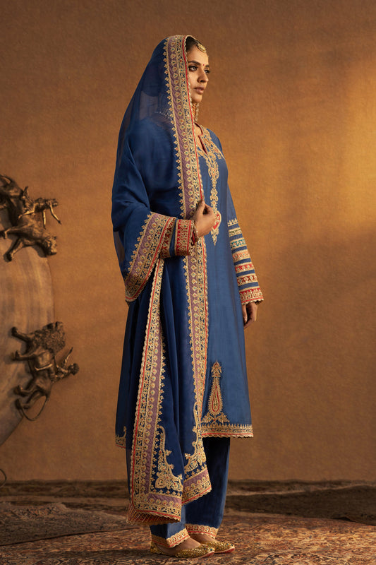 Model in an azure blue kurta set with elaborate gold embroidery, traditional South Asian dress, elegant everyday wear.