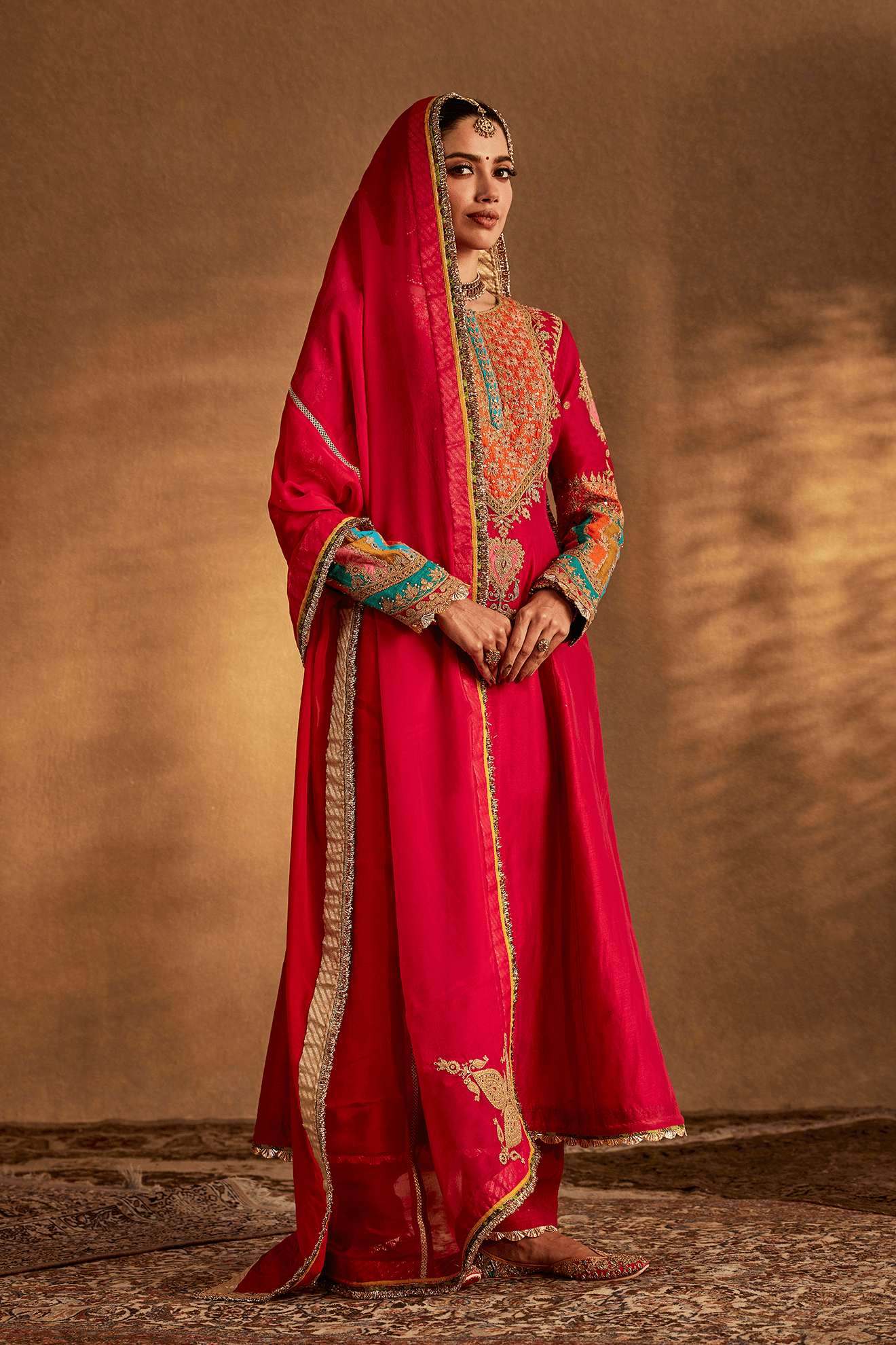Woman in Rani Pink Archival Kurta Set, embroidered traditional South Asian dress, full length.