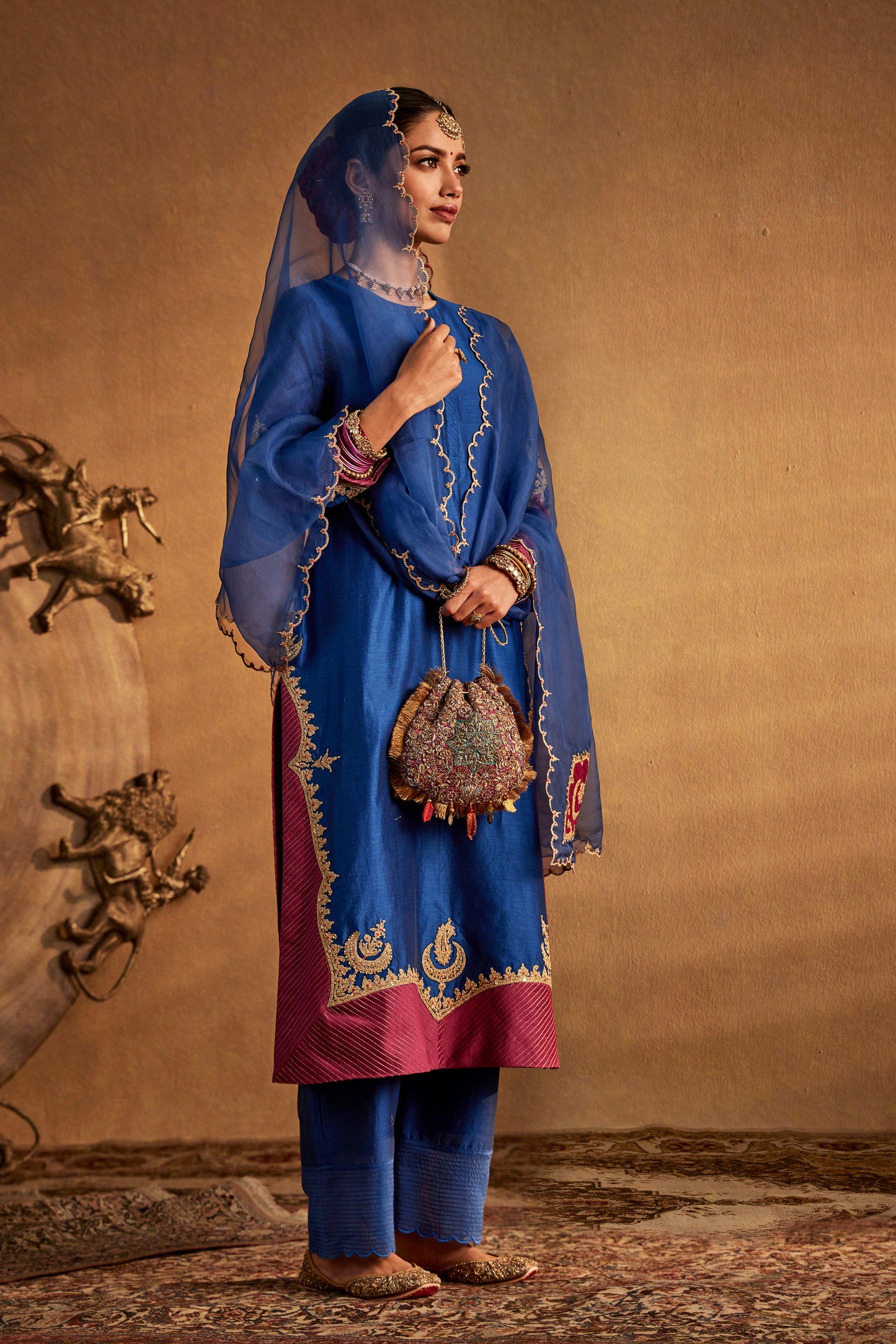 Model in a deep blue kurta set with embroidered details, traditional South Asian fashion, everyday ethnic wear, comfortable.