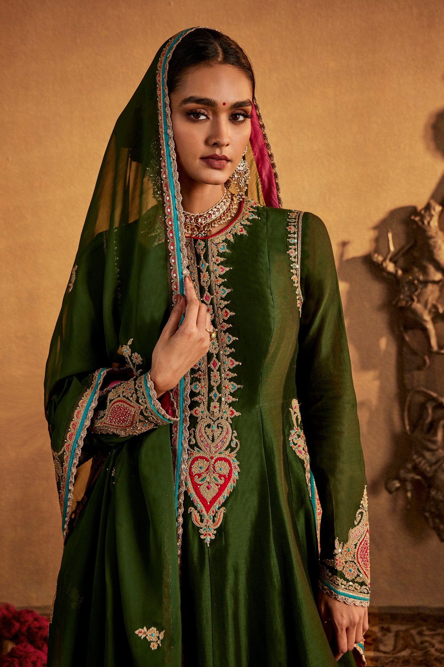 Woman in deep green Mughal peacock kurta set, intricate embroidery, traditional South Asian fashion