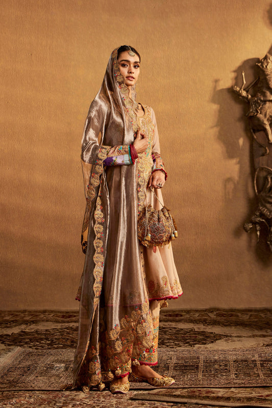 Woman in an embroidered beige traditional South Asian dress, long sleeves, wide skirt, intricate details, formal ethnic wear.