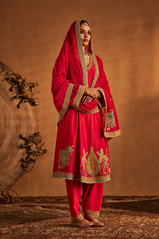 Woman in Rani Pink Kurta Set with embroidered hem, traditional South Asian formal outfit.