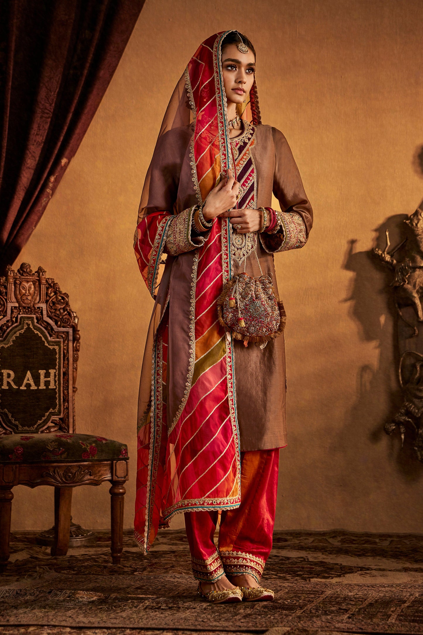 Woman in Brown-Red Kurta Set, colorful striped dupatta, traditional South Asian outfit.