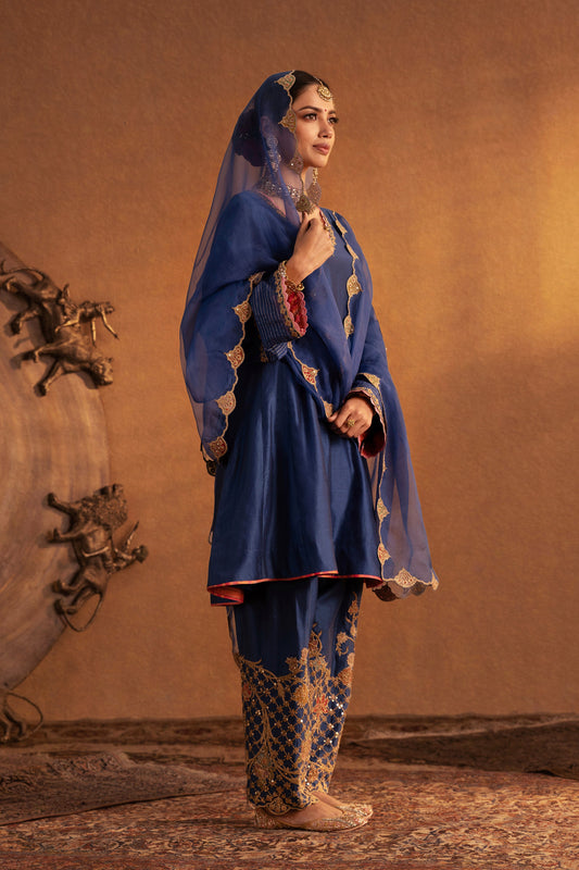 Model in a dark blue Mughal Jaali kurta set, detailed embroidery, traditional South Asian fashion, formal ethnic attire.