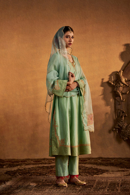 Woman in Blue embroidered kurta and pants, subtle traditional South Asian outfit, full length.