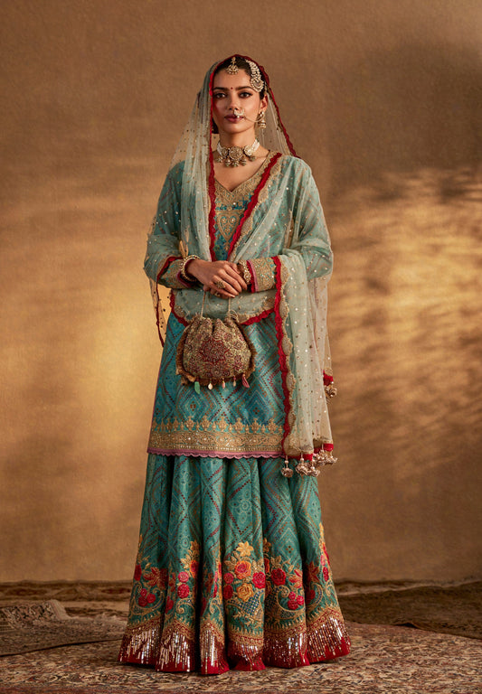 Beautiful turquoise bridal lehenga with red and gold embroidery, complemented by dupatta and traditional bridal accessories.